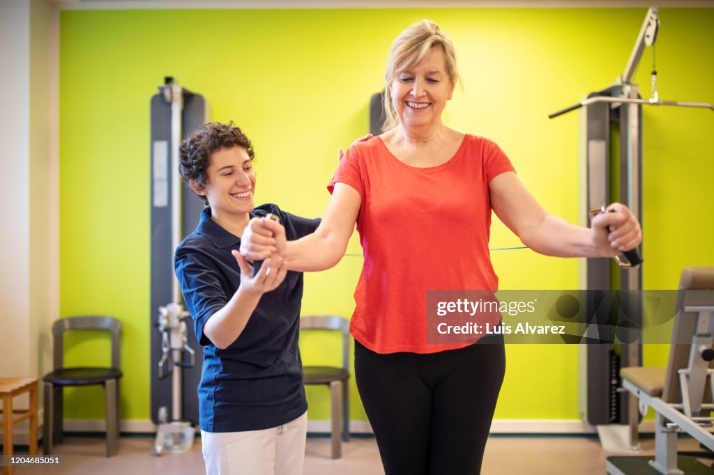 Healthcare worker supporting senior female at rehab