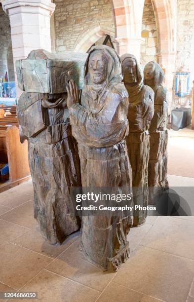 The Journey' Sculpture of monks carrying body of Saint Cuthbert by Fenwick Lawson 1999 Holy Island, Northumberland, England, UK.