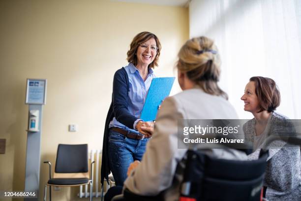 therapist meeting with women in waiting room - rehabilitation meeting stock-fotos und bilder