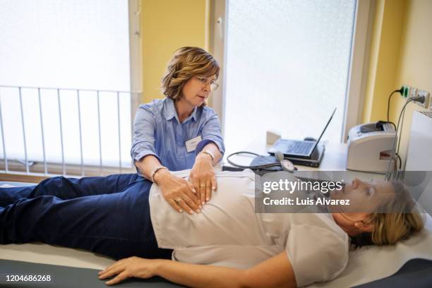 doctor checking patients stomach in a clinic - mage bildbanksfoton och bilder