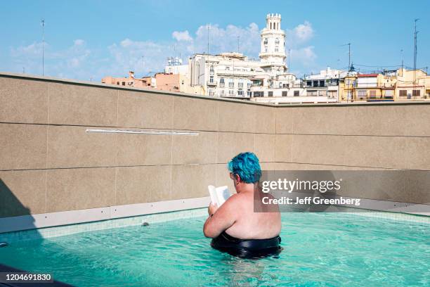 Valencia, Vincci Mercat, hotel rooftop pool with woman reading book.