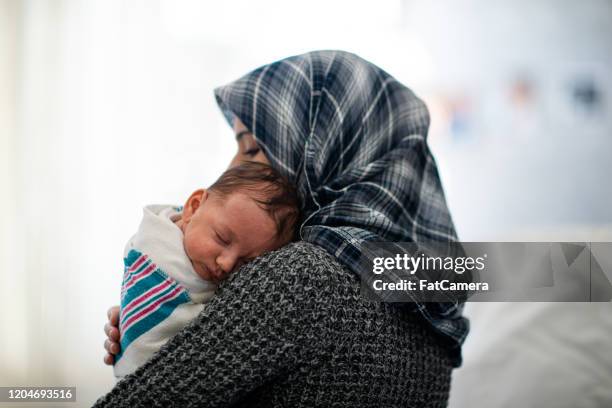 new afghan mother and infant on her shoulder chest stock photo - arab people stock pictures, royalty-free photos & images