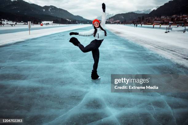 una femmina che si diverte mentre pattina su un lago ghiacciato - pista di pattinaggio su ghiaccio foto e immagini stock