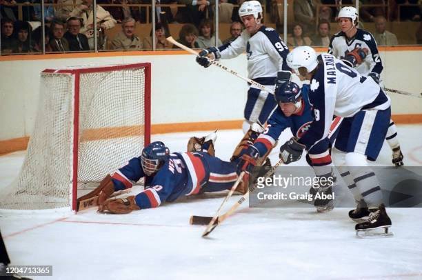 Roland Melanson and Denis Potvin of the New York Islanders skate against Wilf Paiement, Dan Maloney and Darryl Sittler of the Toronto Maple Leafs...