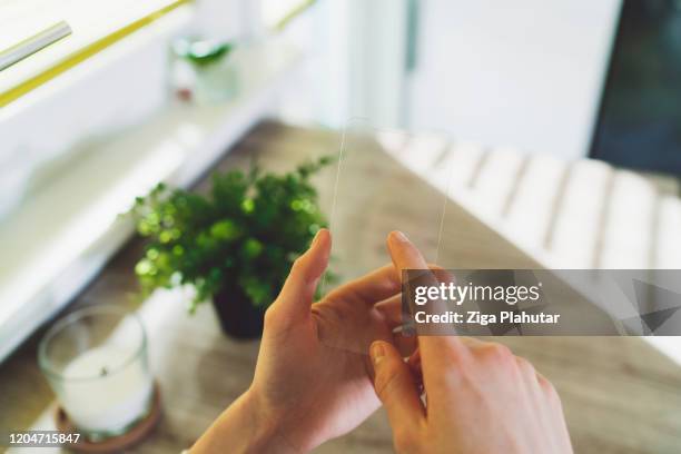 woman hand holding a futuristic smart phone, pressing on the glass screen with one finger - invisível imagens e fotografias de stock