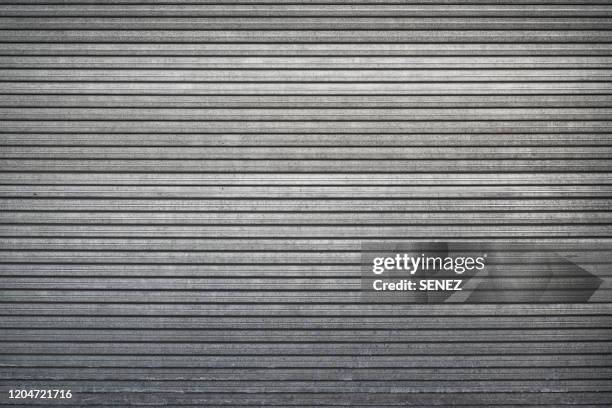 closed steel door / shop shutters - cerrar fotografías e imágenes de stock