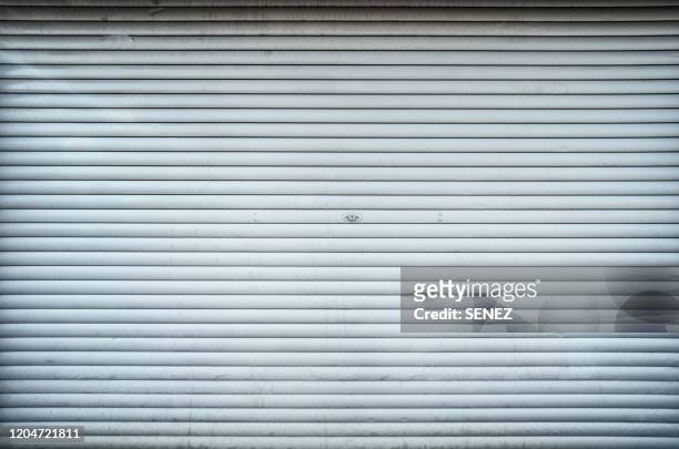 closed steel door / shop shutters - garagentor stock-fotos und bilder