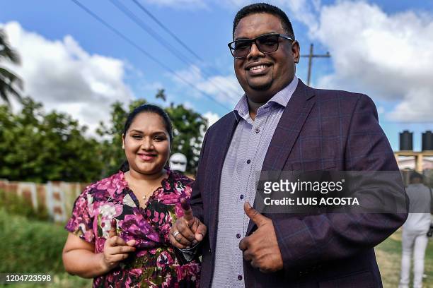 Guyana's presidential candidate for the opposition leftist People's Progressive Party , Mohamed Irfaan Ali, and his wife Arya Ali, show their...