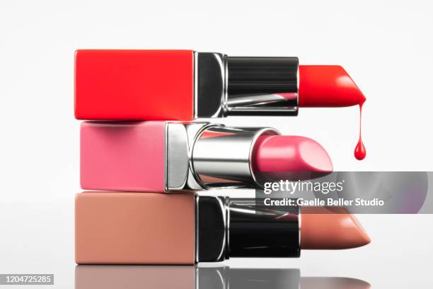 new lipsticks with melting drop against white background - beige lipstick stock pictures, royalty-free photos & images