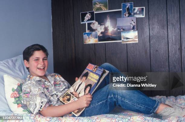 American actor Joaquin Phoenix reads an entertainment magazine at his home in Los Angeles, California, US, circa 1985.
