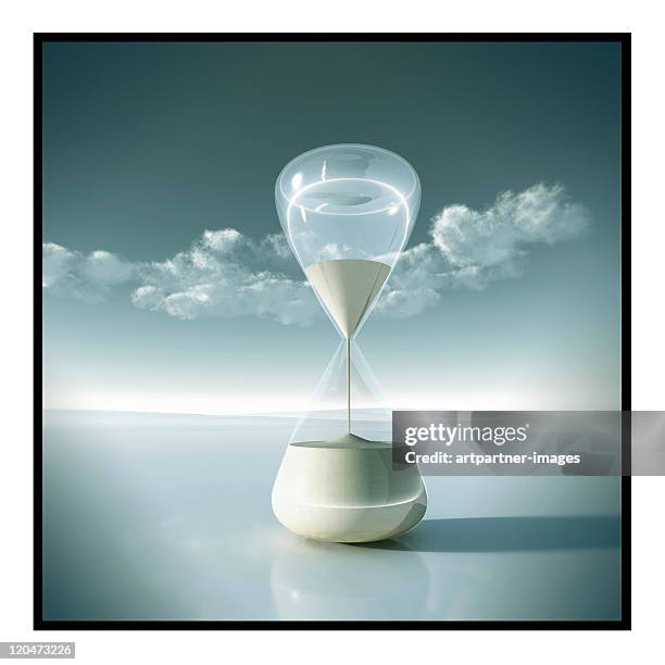 an hourglass in front of a clear sky with clouds - sablier photos et images de collection