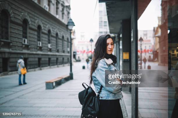young woman walking and looking at the shopping windows - book shop exterior stock pictures, royalty-free photos & images