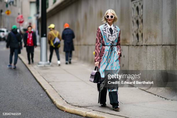 Samantha Angelo wears sunglasses, a white shirt, a dark top, a blue and pink dress with printed geometric patterns and black fringes, a black and...