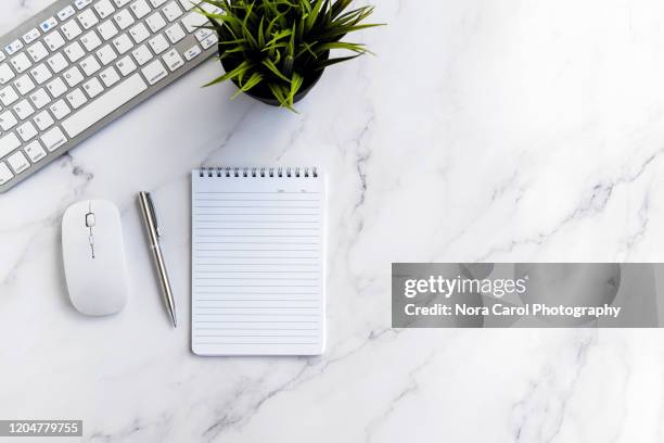 computer keyboard, potted plant, notepad and pen on marble table - notepad white table foto e immagini stock