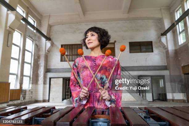 asian young woman dressed in pink plays marimba in ruins - letra w - fotografias e filmes do acervo