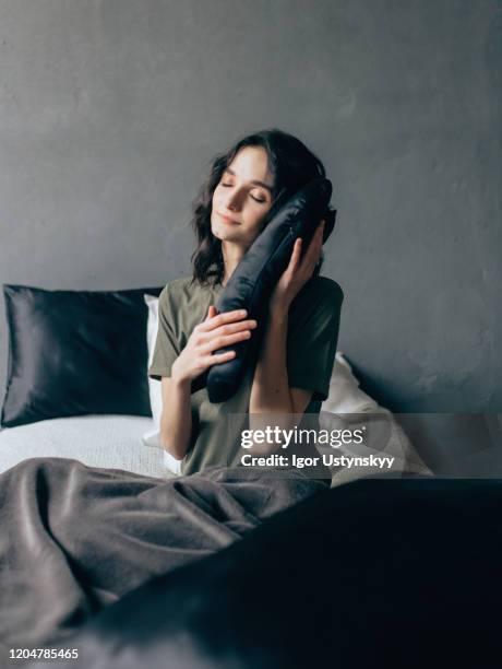 young happy woman embracing pillow - silk cocoon stock pictures, royalty-free photos & images