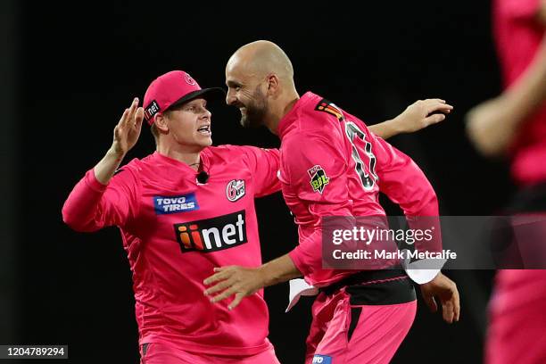 Nathan Lyon of the Sixers celebrates with Steve Smith of the Sixers after taking the wicket of Marcus Stoinis of the Stars during the Big Bash League...