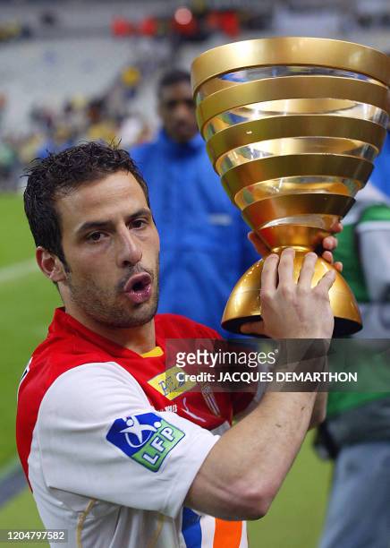 Le milieu de terrain et capitaine de Monaco Ludovic Giuly brandit le trophée de la Coupe de la Ligue, le 17 mai 2003 au Stade de France à...