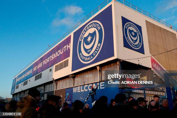 Fans arrive for the English FA Cup fifth round football match between Portsmouth and Arsenal at Fratton Park stadium in Portsmouth, southern England,...