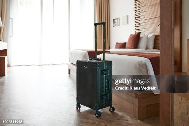 suitcase by bed in hotel room - luggage stockfoto's en -beelden