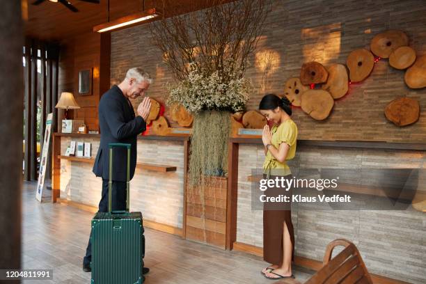 man greeting to receptionist at resort - welcoming guests foto e immagini stock