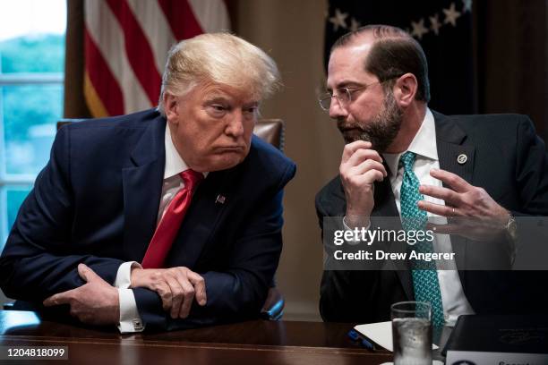 President Donald Trump speaks with Secretary of Health and Human Services Alex Azar during a meeting with the White House Coronavirus Task Force and...