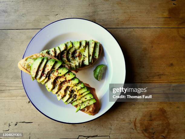 aguacate rebanado en pan de masa agria - avocado slices fotografías e imágenes de stock