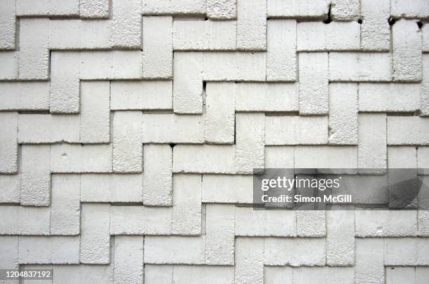 white-painted brick wall in a herringbone relief pattern - herringbone brick stock pictures, royalty-free photos & images