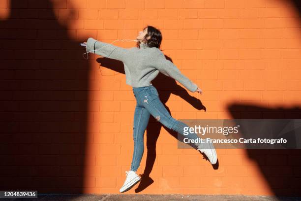 woman listening to the music and jump - throwing phone stock pictures, royalty-free photos & images