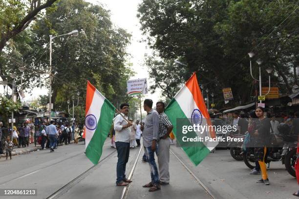 Two men holding the Indian National flag in the middle of the street during a joint rally organised by the Left Front and Indian National Congress...