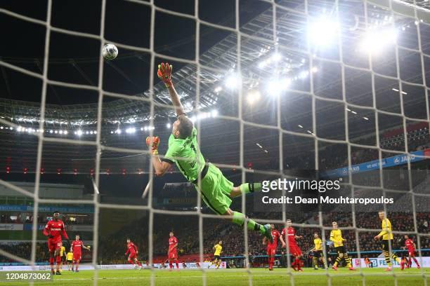 Lukas Hradecky of Bayer 04 Leverkusen dives for the ball as Emre Can of Borussia Dortmund scores his team's second goal during the Bundesliga match...
