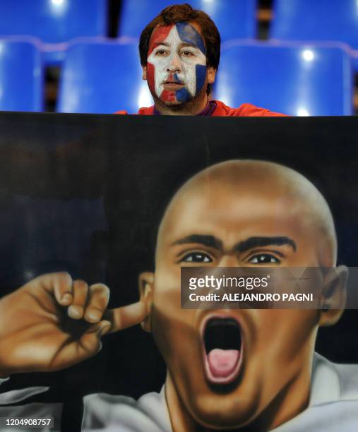 Supporter of Chile holds a flag with an image of Chilean footballer Humberto Suazo, during the 2011 Copa America Group C first round football match...