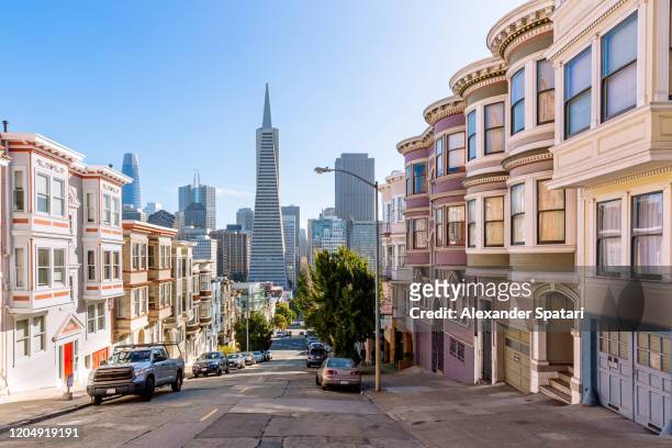 street with residential district with skyscrapers of san francisco financial district in the background, san francisco, california, usa - skyline san francisco stock-fotos und bilder