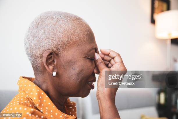 senior woman with a headache - shaved head profile stock pictures, royalty-free photos & images