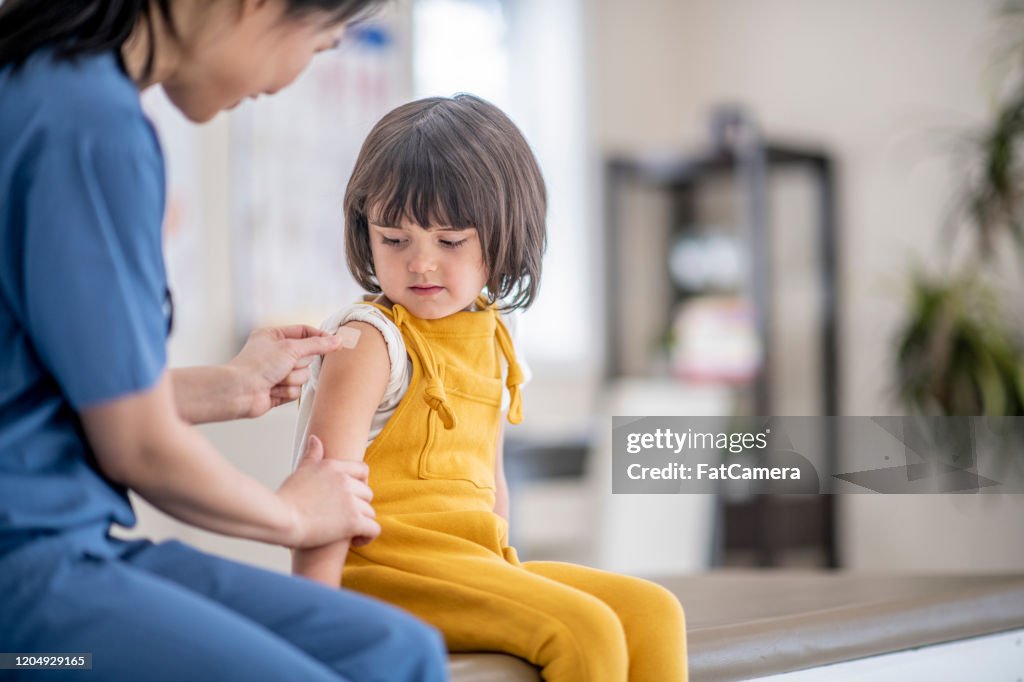 Doctor Putting a Bandage on a Young Girl stock photo