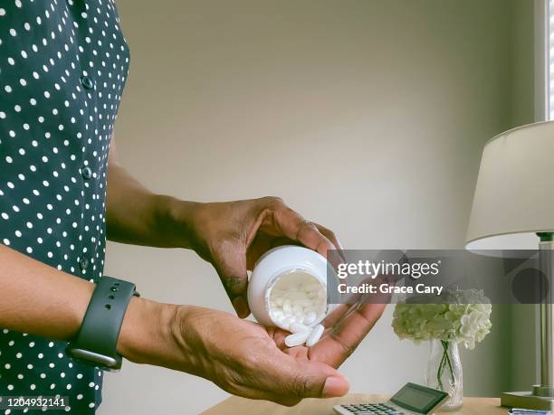 close-up of woman pouring pills into palm of hand - paracetamol stock pictures, royalty-free photos & images