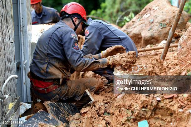 Firefighters search for victims of a landslide at the Morro do Macaco Molhado favela in Guaruja, 95 km from Sao Paulo, on March 3, 2020 after...