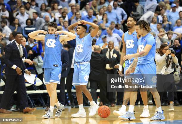 Teammates Andrew Platek, Christian Keeling, Garrison Brooks and Cole Anthony of the North Carolina Tar Heels walk off the court after being defeated...
