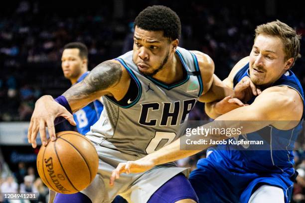 Miles Bridges of the Charlotte Hornets is guarded by Ryan Broekhoff of the Dallas Mavericks during the fourth quarter during their game at Spectrum...