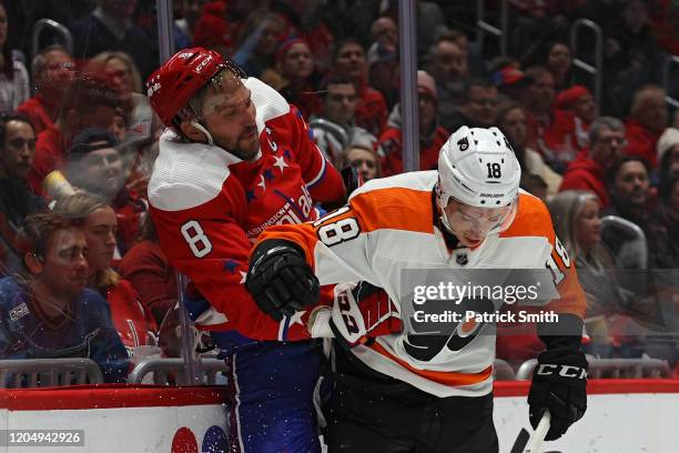 Alex Ovechkin of the Washington Capitals is checked by Tyler Pitlick of the Philadelphia Flyers during the third period at Capital One Arena on...