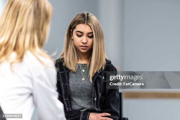 depressed young girl in a counseling session stock photo - depressed teenager stock pictures, royalty-free photos & images