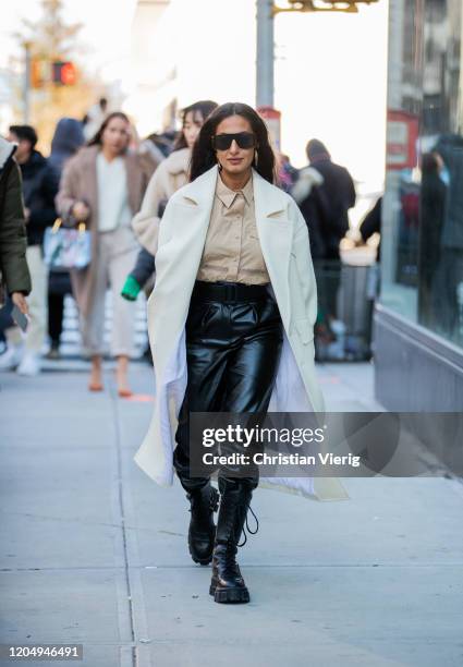 Nausheen Shah is seen wearing black high waist pants, beige button shirt, white coat outside Self-Portrait during New York Fashion Week Fall/Winter...