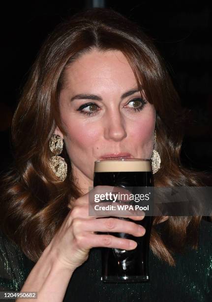 Catherine, Duchess of Cambridge drinks a pint of Guinness during a reception with Prince William, Duke of Cambridge, hosted by the British Ambassador...