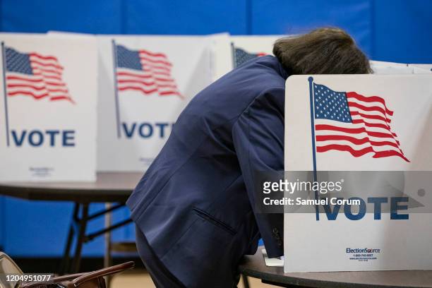 Woman marks down her vote on a ballot for the Democratic presidential primary election at a polling place in Armstrong Elementary School on Super...