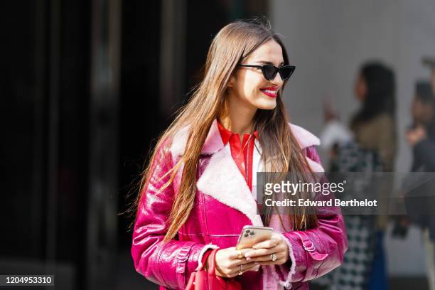 Gabrielle Caunesil wears sunglasses, a pink leather aviator long jacket with wool inner lining, outside Longchamp, during New York Fashion Week...