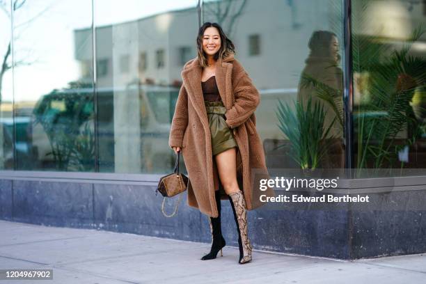 Aimee Song wears a brown long fluffy coat, a bustier, green leather shorts, snake pattern printed boots, a Vuitton monogram bag, outside Self...