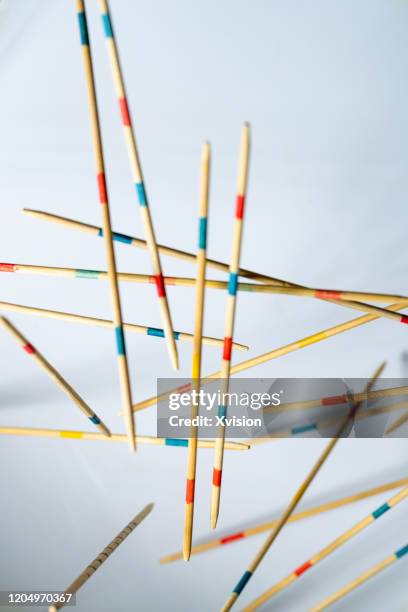 mikado spiel game bamboo stick flying in mid air with white background - mikado stock pictures, royalty-free photos & images