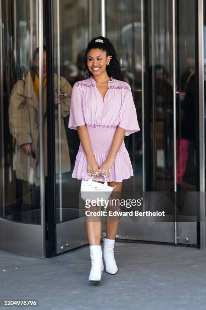 Leyna Bloom wears a pink/purple ruffled and pleated dress, white boots, outside Longchamp, during New York Fashion Week Fall-Winter 2020, on February...