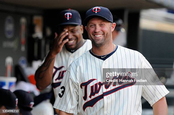 Delmon Young and Michael Cuddyer of the Minnesota Twins smile in the dugout before the game against the Detroit Tigers on July 22, 2011 at Target...