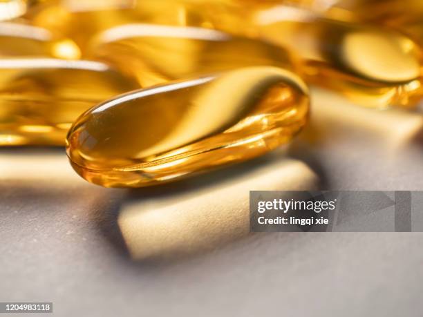 golden cod liver oil capsules in the sun - fish oil ストックフォトと画像